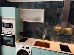 a kitchen with a sink and a microwave at Caldasia in Caldas de Reis