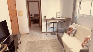 a living room with a couch and a table at Apartamento perto do HCAA - com Garagem in Santa Maria