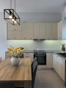a kitchen with a table with a vase of flowers on it at Lūm Posidonia in Posidhonía