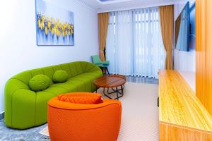 a living room with a green couch and a table at T-Stone Apartments Hotels -Kigali in Kigali +10 photos