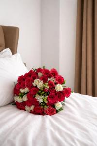 a bouquet of red and white roses on a bed at T-Stone Apartments Hotels -Kigali in Kigali