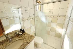 a bathroom with a sink and a toilet and a shower at Pousada House Garden in Goiânia +10 photos