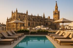 a hotel with a pool and a building with a clock tower at Serras Sevilla in Seville