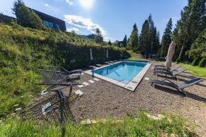 a swimming pool with two chairs and an umbrella at PROSTIR in Korostov
