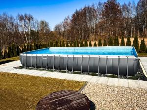 a large swimming pool in a yard with trees at POKOJE GOŚCINNE U MIKOŁAJA in Pękanino