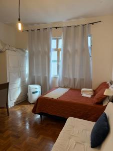 a bedroom with two beds and a window at Apartamento Centro Imperial de Petrópolis in Petrópolis +6 photos