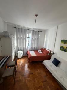 a bedroom with two beds and a table and a chair at Apartamento Centro Imperial de Petrópolis in Petrópolis