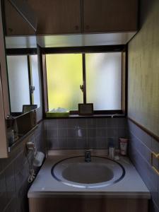 a bathroom with a sink and a window at Cozy Koharuka in Shima
