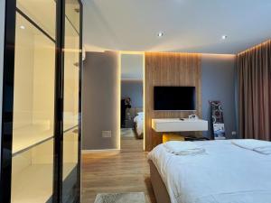 a bedroom with a bed and a sink and a television at Luxury Apartment in Shkodër