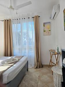 a bedroom with a bed and a window with curtains at Malindi Getaway, Near Beach in Malindi
