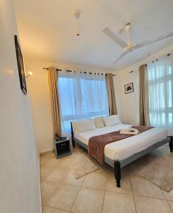 a bedroom with a bed and a ceiling fan at Malindi Getaway, Near Beach in Malindi +17 photos