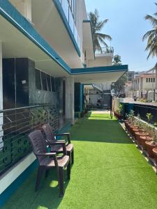 a balcony with chairs and grass on a building at Raaha Residency in Mysore