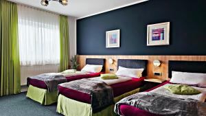 two beds in a hotel room with blue walls at Gasthof Alte Schule in Fürstenzell