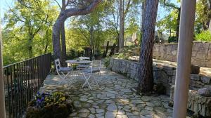a patio with two trees and a table and chairs at Bosquet de l'Auró in Argençola