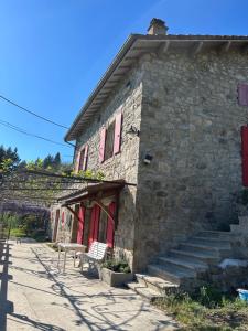 a stone building with a bench in front of it at Gîte Les Vignes au Cheylard in Le Cheylard