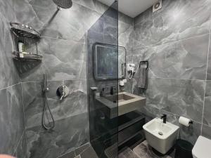 a bathroom with a sink and a shower at Luxury Apartment in Shkodër +25 photos