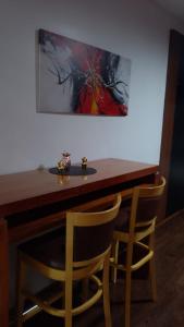 a dining table with two chairs and a painting on the wall at Apart Rilax in Buenos Aires
