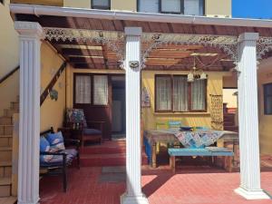 a patio with two white columns and a table at 65 Rowweklip in Jongensfontein