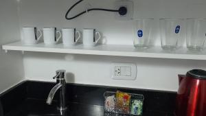 a kitchen counter with white cups on a shelf at Apart Rilax in Buenos Aires