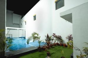 a courtyard with plants and a swimming pool at White Forest - PV Hotels in Pondicherry