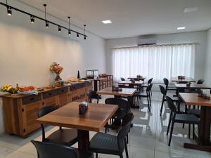 a dining room with wooden tables and chairs at Modelo Prime Hotel in Ribas do Rio Pardo