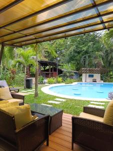 a patio with chairs and a swimming pool at Villas Kiki in Puerto Viejo