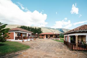 a walkway between two buildings with mountains in the background at Cabañas Sol y Luna in Villa de Leyva