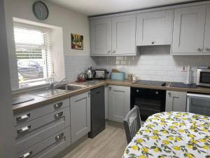 a small kitchen with white cabinets and a table and a table and a table at The Dairy Nolans organic farm in Ramsgrange