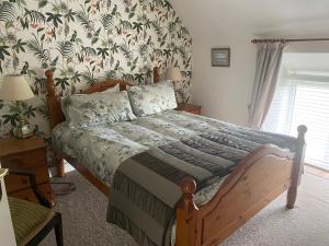 a bedroom with a bed with a floral wallpaper at The Dairy Nolans organic farm in Ramsgrange