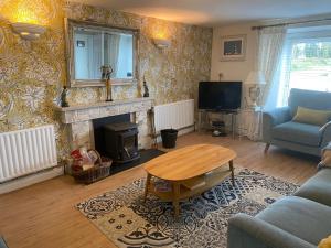 a living room with a table and a fireplace at The Dairy Nolans organic farm in Ramsgrange