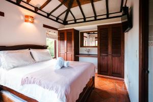a bedroom with a bed with a teddy bear on it at Cabañas Sol y Luna in Villa de Leyva