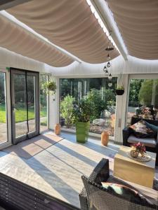 a patio with awning and chairs and a table at Evia Ferienwohnung in Heimbach +12 photos
