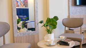 a table with two chairs and a potted plant on it at Central Park Hotel İstanbul in Istanbul