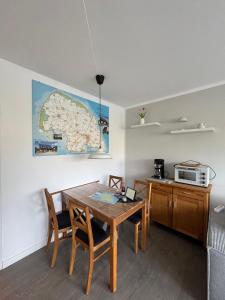 a dining room with a table and a map on the wall at Beachpoint-Fehmarn in Burgtiefe auf Fehmarn 