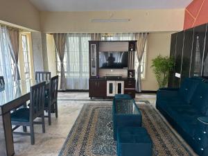 a living room with a tv and a couch at Raaha Residency in Mysore