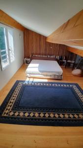 a bedroom with a bed and a rug on the floor at Verdure, rivière et vue imprenable in Sallelles