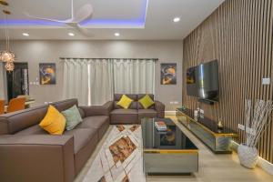 a living room with a couch and a flat screen tv at Golden Pear Villa-MSV 10BR - 5 Fully Equipped Kitchens, Harbor & Sea Views in Morne Longue