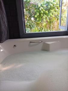 a bath tub with a window in a bathroom at Luz de Cabana in Santo Amaro da Imperatriz +40 photos