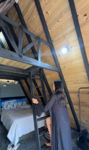 a woman is standing next to a bunk bed at Luz de Cabana in Santo Amaro da Imperatriz