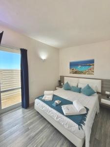 a bedroom with a bed with a view of the ocean at Stabilimento Lido Burrone in Favignana