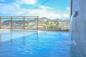 a large swimming pool with a view of a city at Golden Pear Villa-MSV 10BR - 5 Fully Equipped Kitchens, Harbor & Sea Views in Morne Longue