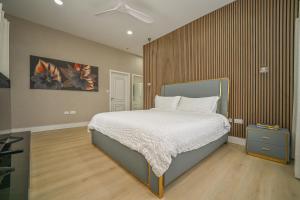 a bedroom with a bed with a wooden wall at Golden Pear Villa-MSV 10BR - 5 Fully Equipped Kitchens, Harbor & Sea Views in Morne Longue +84 photos