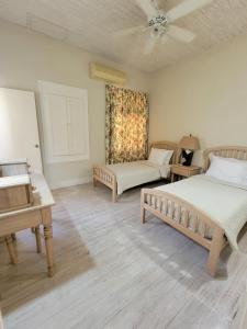 a bedroom with two beds and a piano at Clariston in Bridgetown