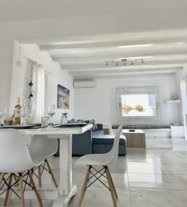 a white living room with a table and chairs at Villa Greystone & Sky Mykonos in Tourlos