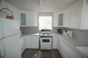 a white kitchen with a stove and a refrigerator at Clariston in Bridgetown +10 photos