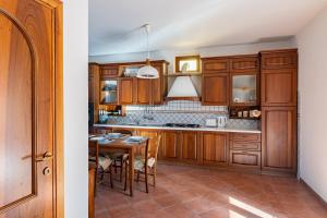 a kitchen with wooden cabinets and a table at Vecchia San Giovanni - YourPlace Abruzzo in Fossacesia