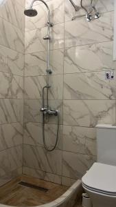 a shower in a bathroom with a marble wall at Sun Ray Apartments Thassos in Limenas +82 photos