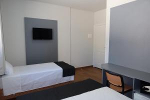 a bedroom with a bed and a tv on the wall at B Hotel 888 hotéis - Próximo a Rodoviária e Praça Sete in Belo Horizonte
