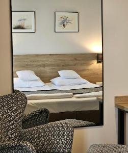 two beds in a room with a mirror and a chair at VILLA LIPOVA STEGNA pokoje i apartamenty dedykowane osobom dorosłym in Stegna