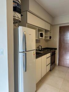 a kitchen with a white refrigerator in a room at Monoambiente 2 Village Golf in Yerba Buena